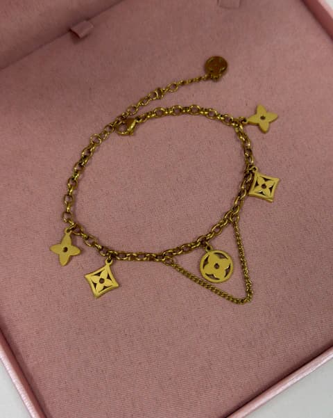 Pulseira berloques flor vazada aço dourado