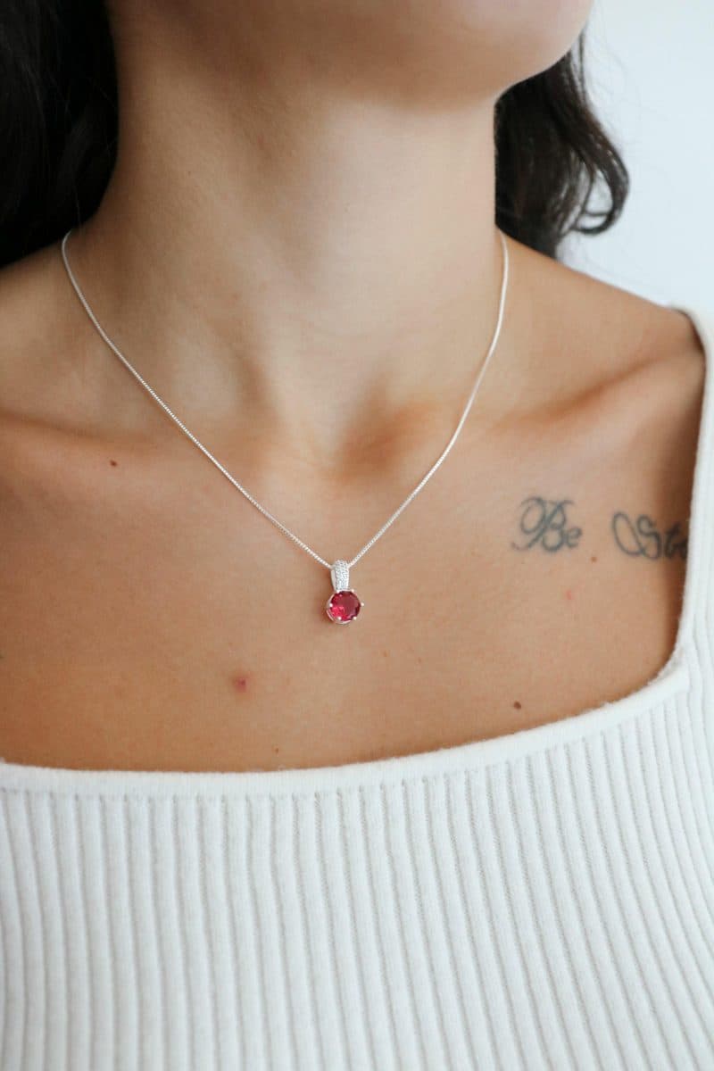 Colar ponto de luz rosa fucsia contra argola cravejada