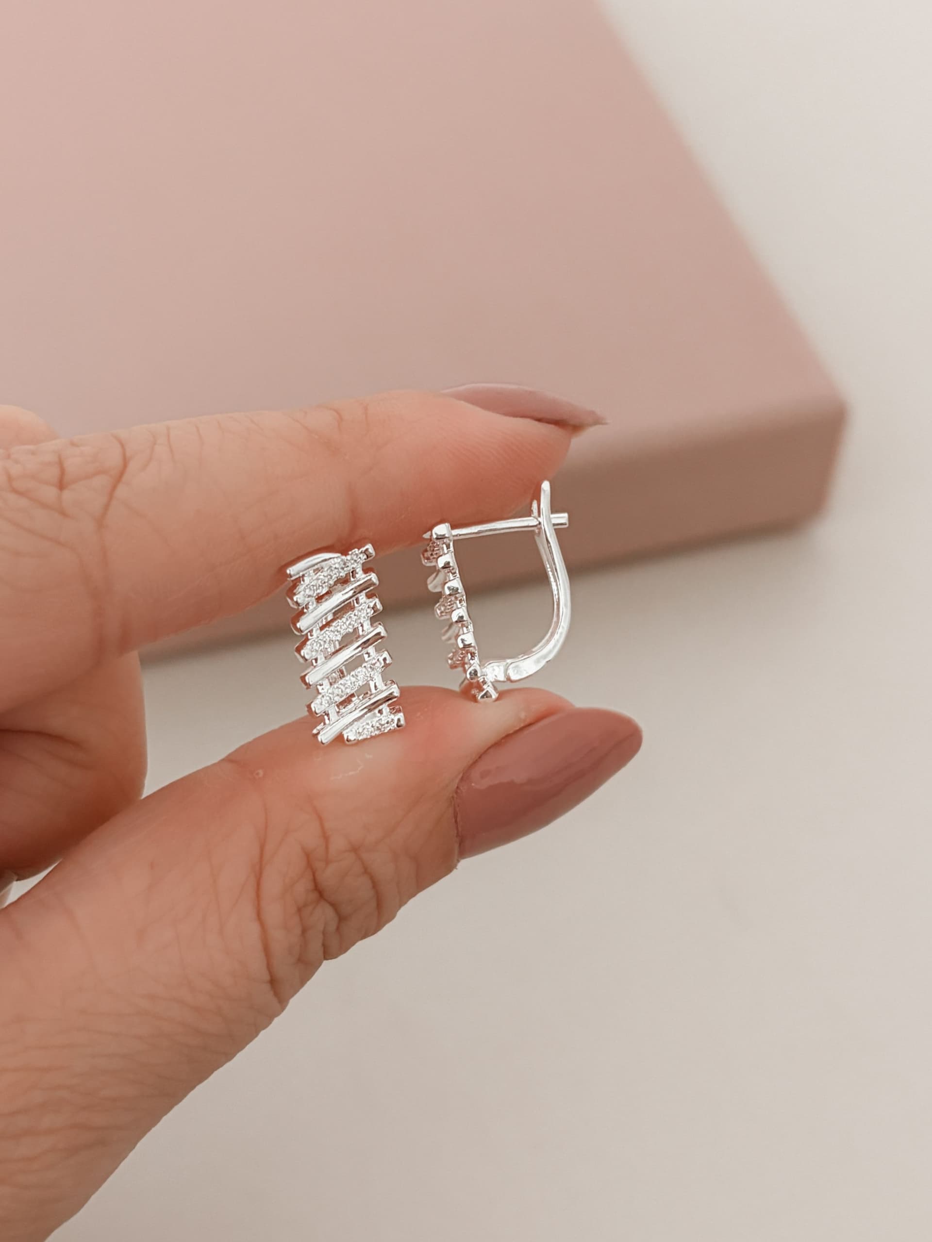 Argola oval com traços cravejados e lisos