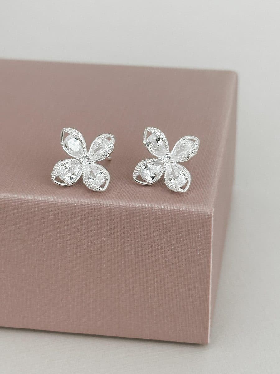 Brinco flor quatro pétalas com detalhes cravejados